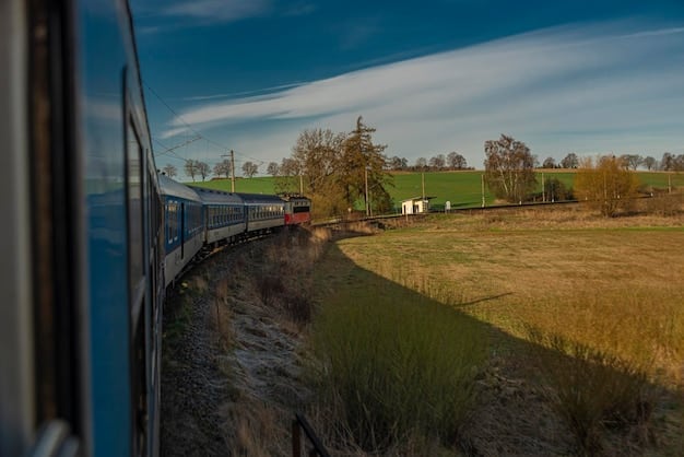 A modern railway line with a train passing through a rural landscape, symbolizing improved transportation infrastructure and regional connectivity.